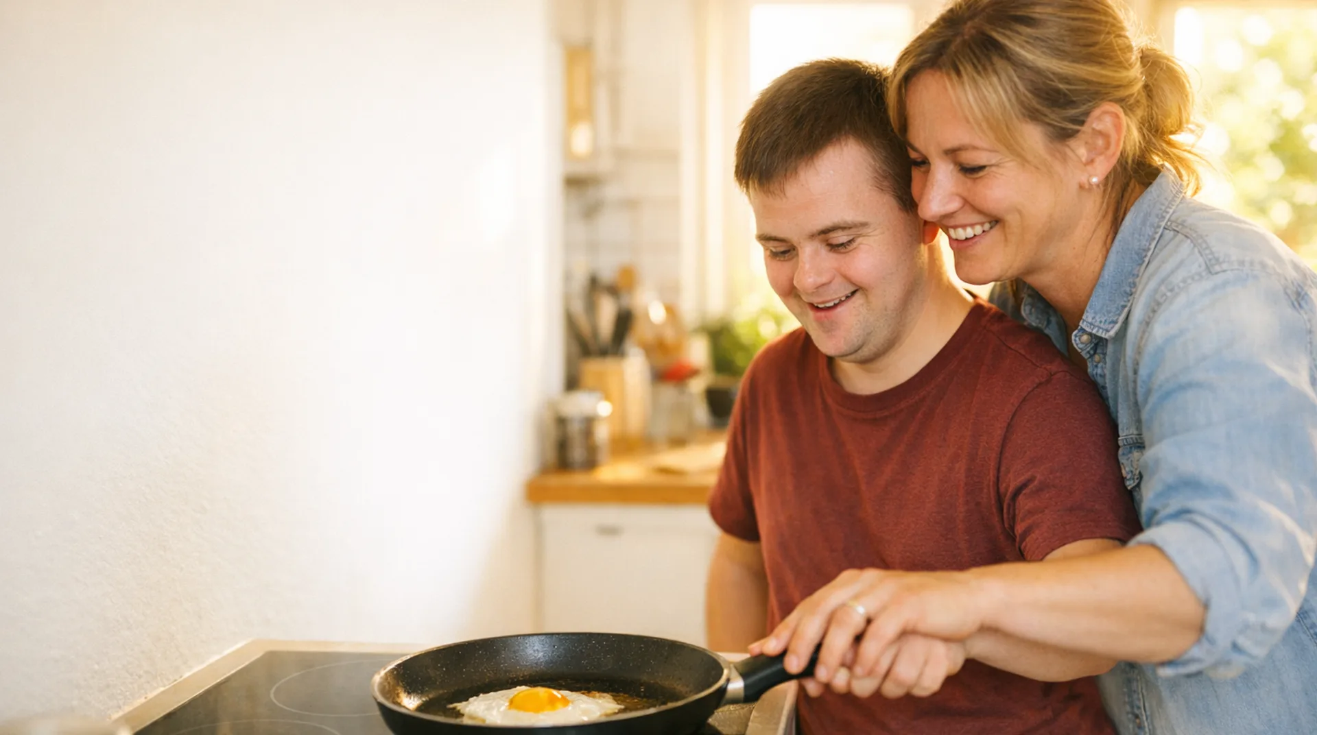 Betreuerin übt mit einem jungen Mann Schritt für Schritt das Kochen